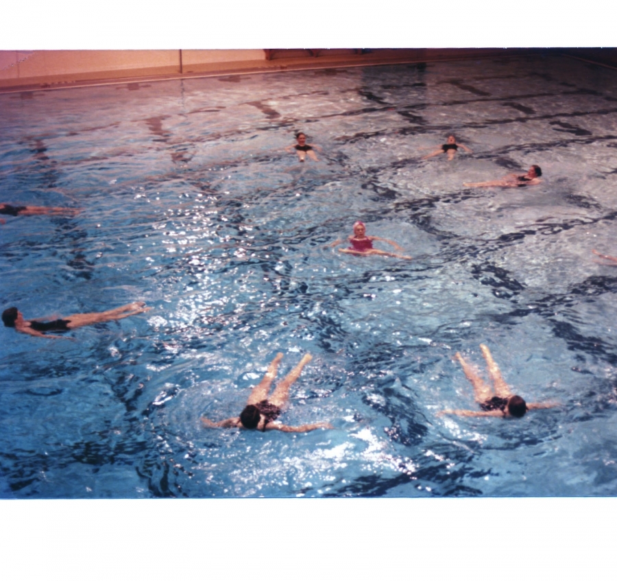 synchronized swimmers in pool performing in a circle